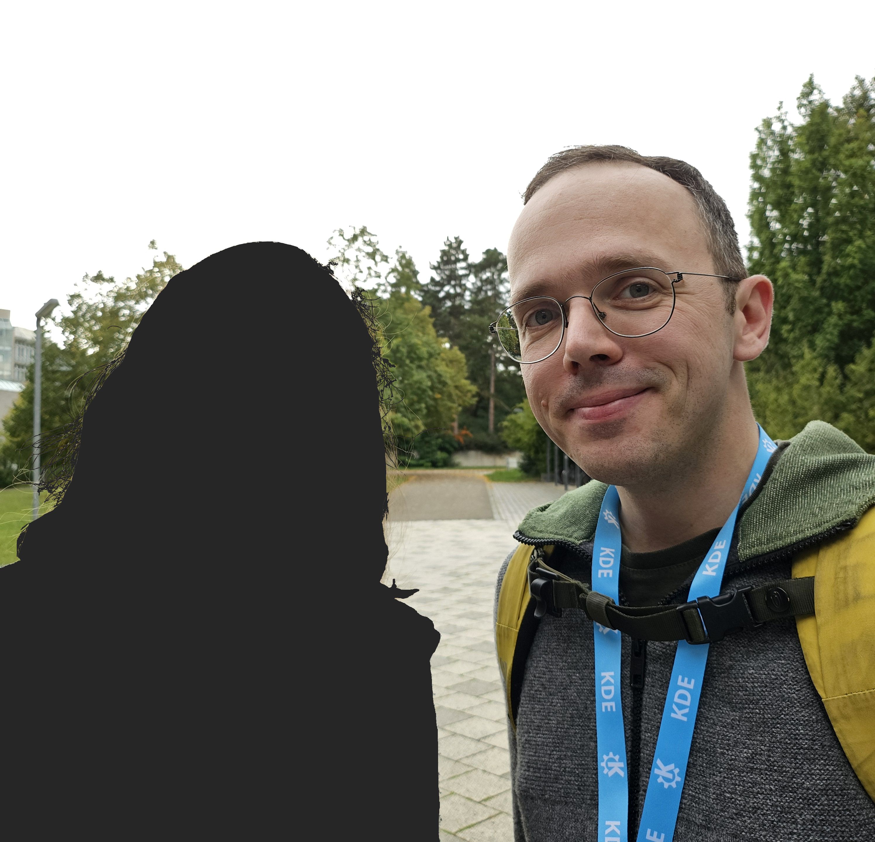 Akademy's no-photo badge makes its wearer disappear from selfies. AI magic, perhaps?